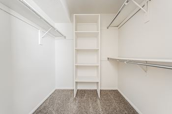 A white shelving unit in a room with a carpeted floor.